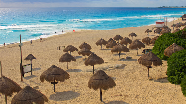 Delfines Beach near Dreams Vista Cancun Golf & Spa Resort with wide sandy shoreline and iconic Cancun sign