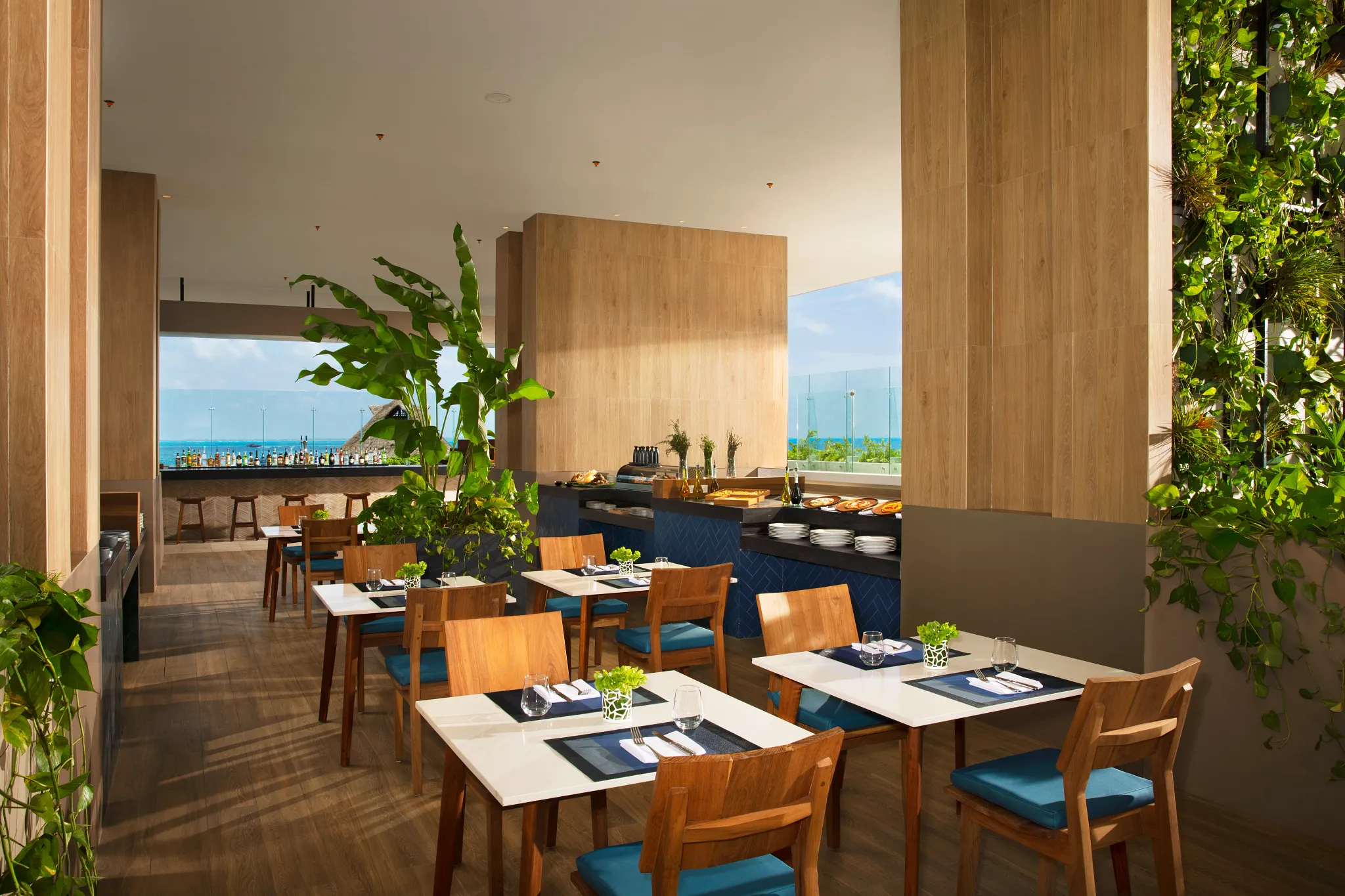 La Plaza gourmet food court at Dreams Vista Cancun featuring multiple international food stations and open-air seating with a vibrant casual atmosphere.