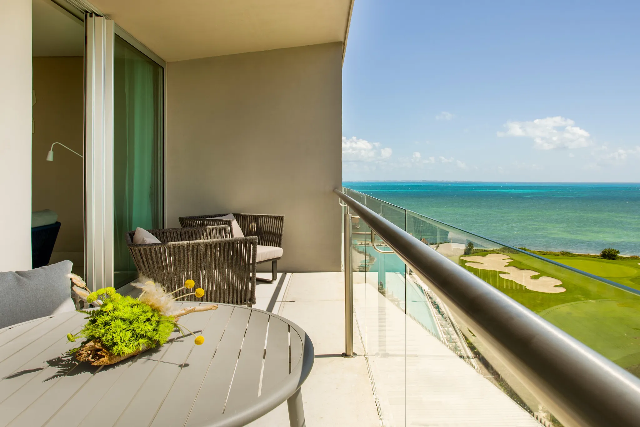 Preferred Club Corner Suite Ocean View terrace with seating and panoramic ocean and golf course views at Dreams Vista Cancun.