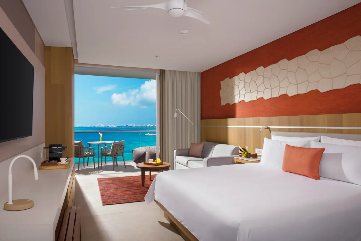Preferred Club Deluxe Ocean View room with king bed, modern décor, and private balcony overlooking the Caribbean at Dreams Vista Cancun.