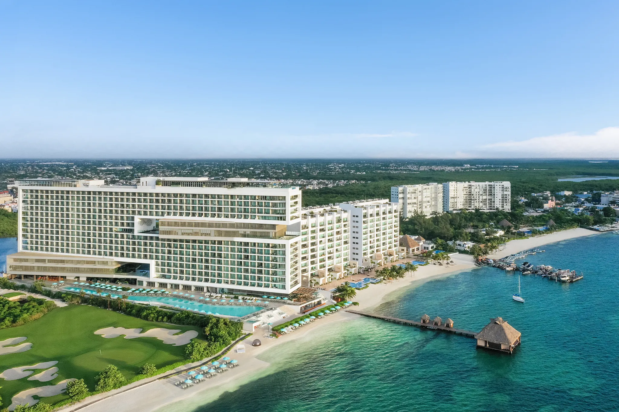 Aerial view of Dreams Vista Cancun Golf & Spa Resort with beachfront, golf course, and turquoise water.