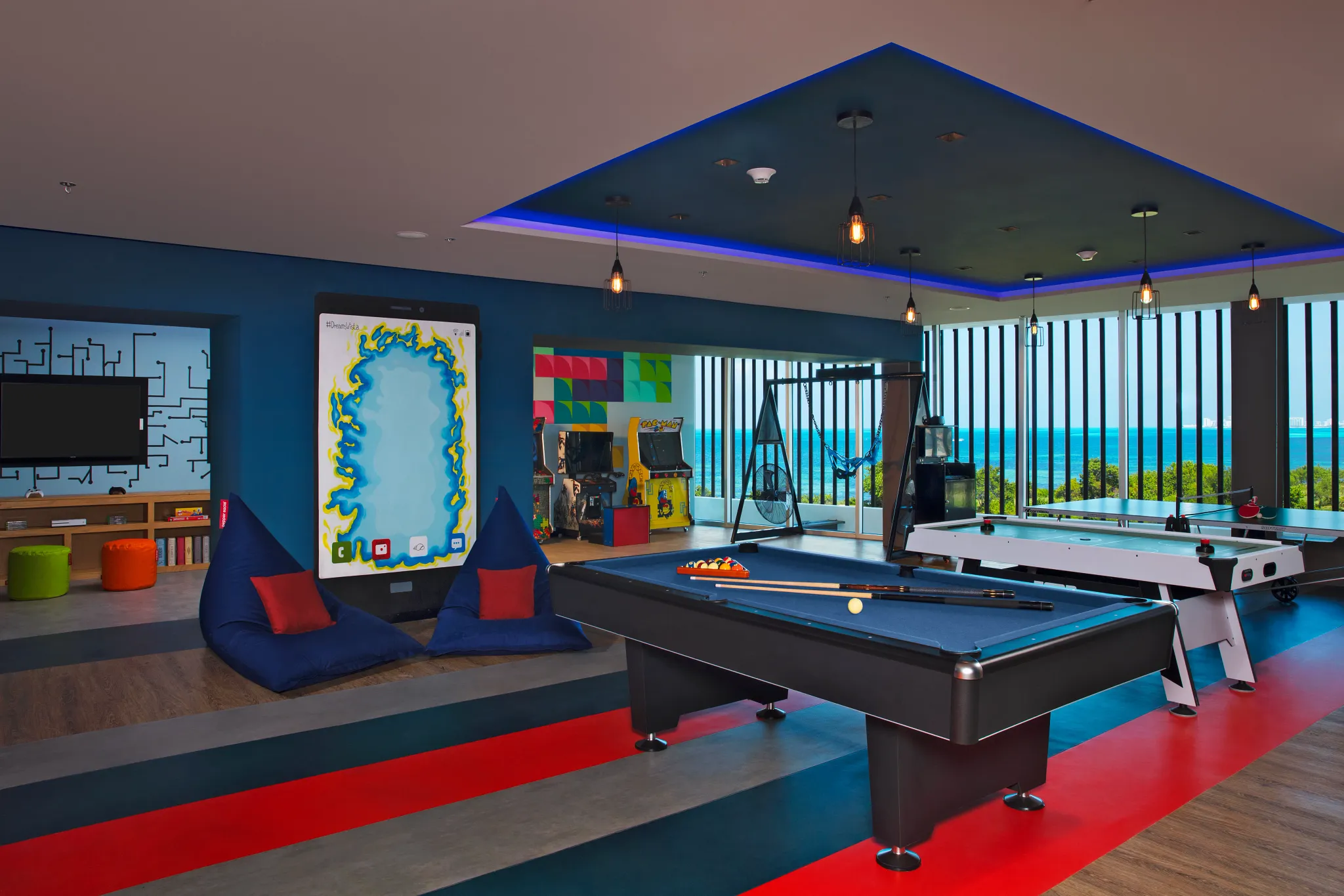 Teen game lounge with pool table, arcade games, and ocean views at Dreams Vista Cancun Golf & Spa Resort.