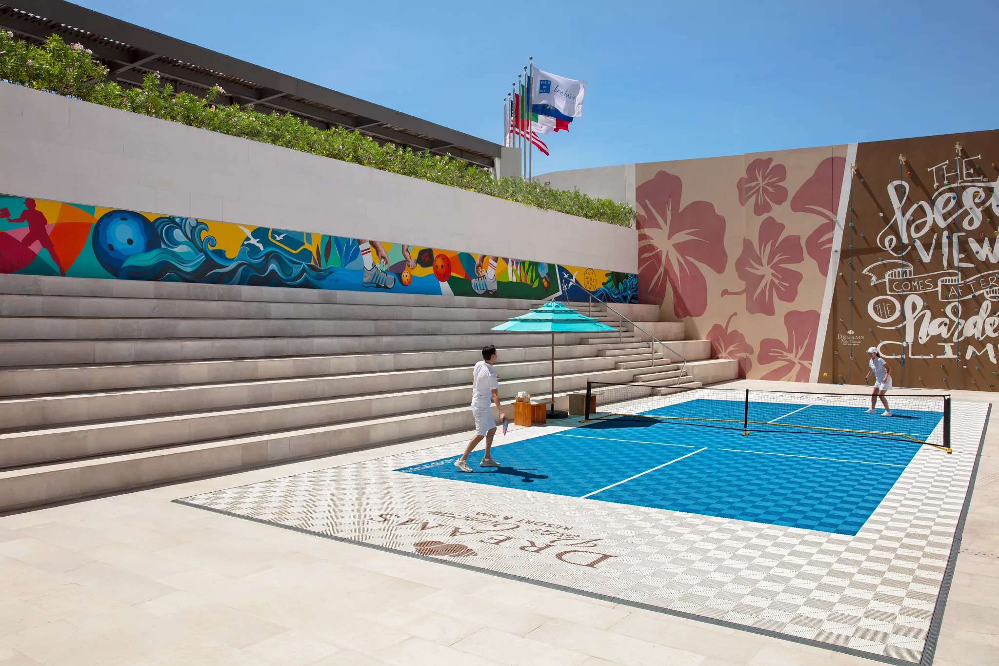 Pickleball court with colorful mural and players at Dreams Vista Cancun Golf & Spa Resort.